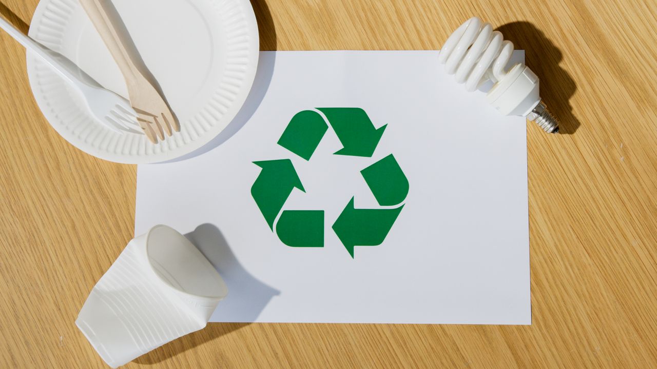 services-01 Eco-friendly utensils, light bulb, and recycling symbol on paper emphasize sustainable living.
